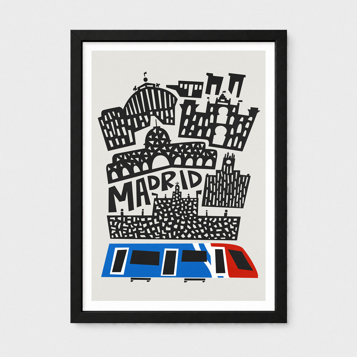 A framed art print featuring a stylized black line-art illustration of Madrid landmarks and the word 'MADRID' on a light gray background, with a blue and red train at the bottom. The print is mounted with a white mat and enclosed in a black frame, shown against a light gray wall.