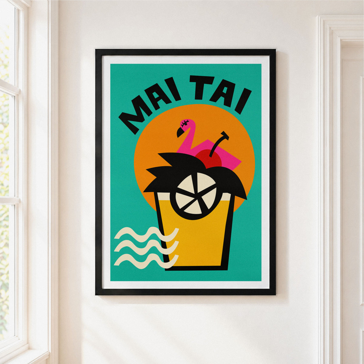 A framed 'Mai Tai' cocktail art print with a black frame and white mat, hanging on a white wall next to a window.