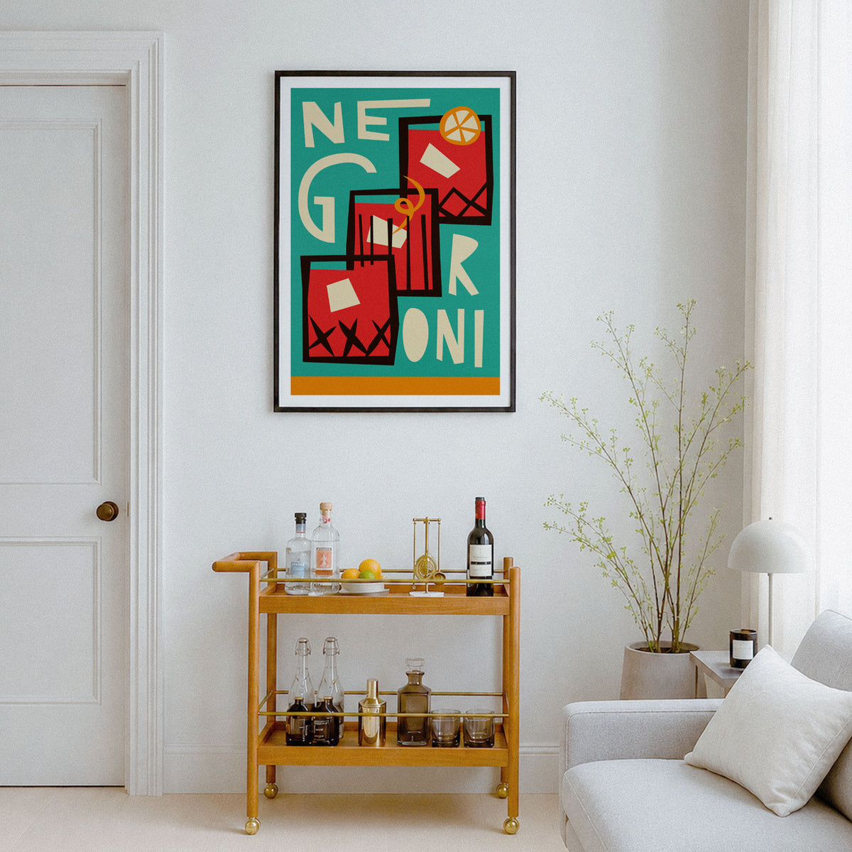 A framed abstract art print featuring the words 'NEGRONI' in bold red, black, white, and yellow geometric shapes over a teal background, hanging on a white wall above a gold bar cart in a modern living room setting.