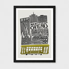 Framed New Orleans cityscape art print with black buildings, the words 'NEW ORLEANS,' and an olive-green streetcar on a light gray background, shown in a black frame against a light gray wall.