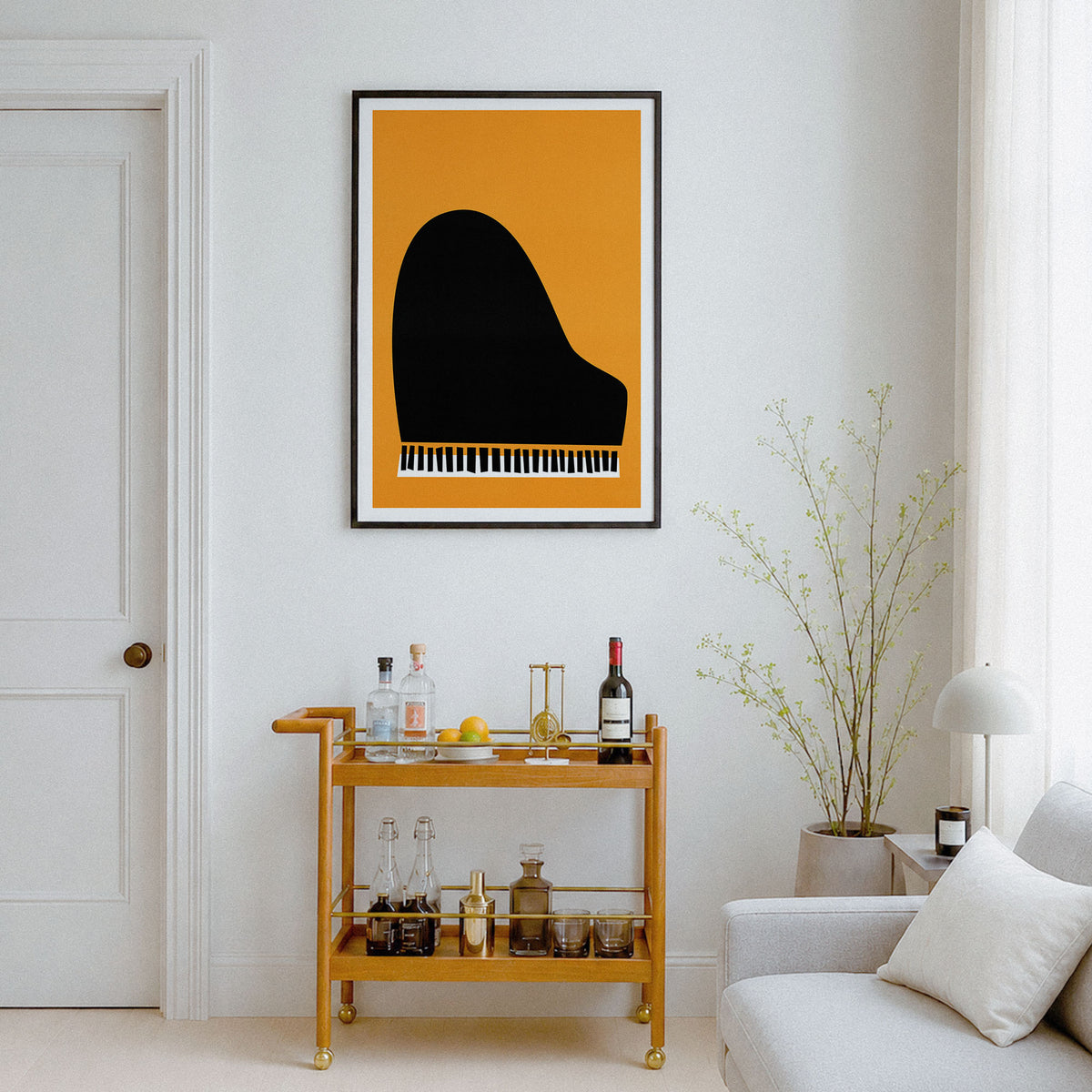 A framed art print featuring a minimalist black grand piano silhouette on a mustard yellow background, displayed on a white wall in a modern living room setting above a gold bar cart.