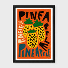 A framed art print featuring a retro-style illustration of three yellow pineapples with green tops on an orange background, surrounded by bold black and cream text reading 'PINEAPPLE'. The print is housed in a black frame with a white mat, shown against a light gray background.