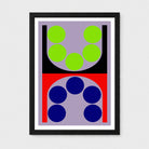A framed abstract geometric art print featuring a symmetrical design with lime green circles on a lavender background in the top half, and dark blue circles on a red background in the bottom half, enclosed in a black frame with a white mat.