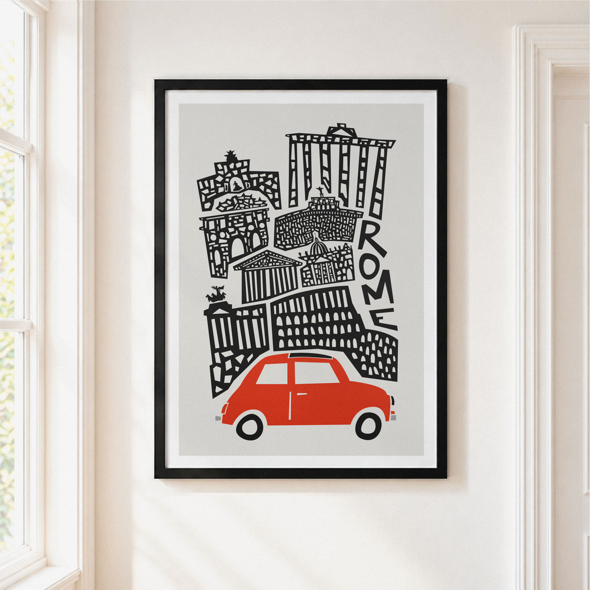 A framed art print featuring a stylized black line drawing of Rome with a red car at the bottom, displayed on a light beige wall in a doorway.