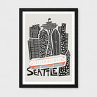 A framed Seattle cityscape art print featuring stylized black buildings, the Space Needle, a white and red tram, and the word "SEATTLE" in black on a light gray background, shown in a black frame against a light gray wall.