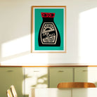 A framed art print of a retro soy sauce bottle on a teal background, hanging on a cream-colored wall above a green cabinet in a modern room.