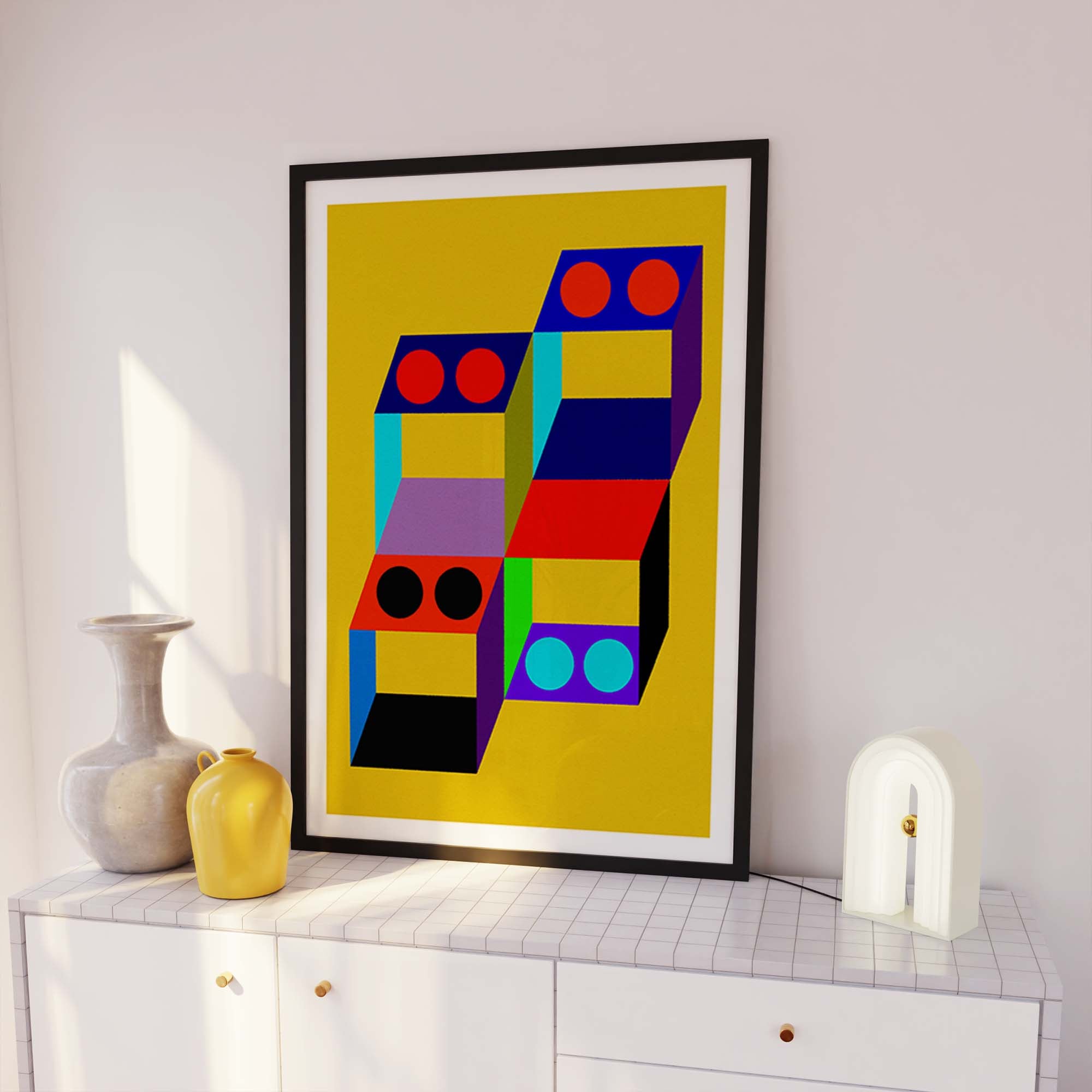 Colorful geometric abstract art print in a black frame on a white wall.