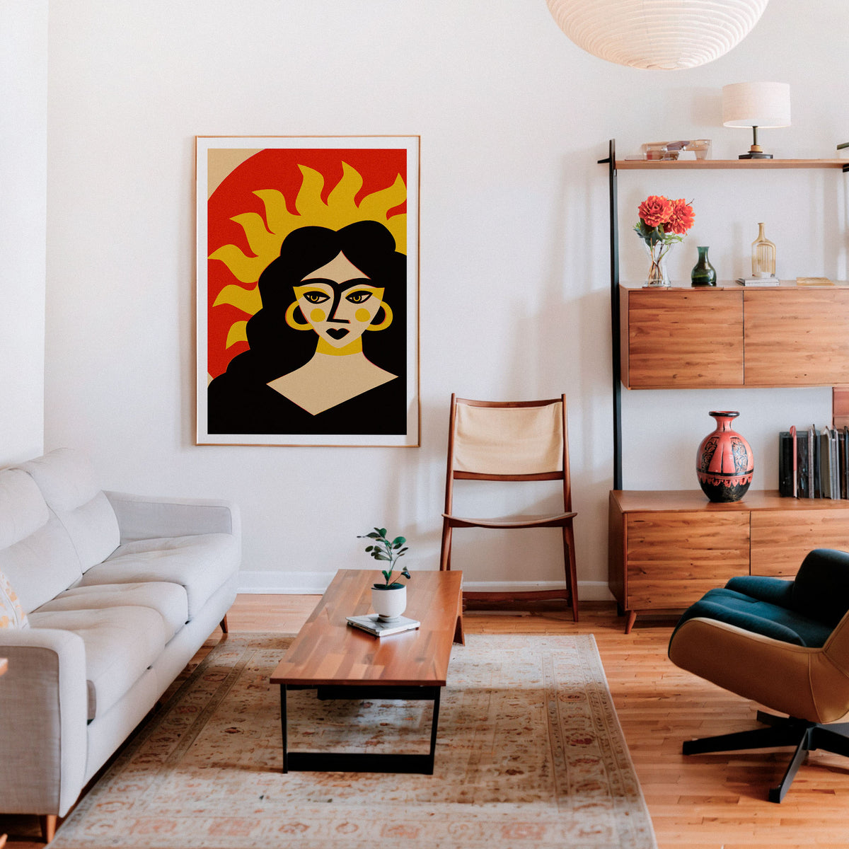 A framed art print featuring a stylized woman with a sunburst background, displayed on a white wall in a modern living room setting with a sofa, coffee table, and shelving.