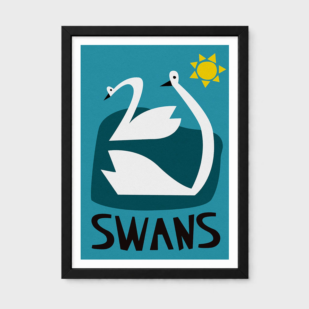 A framed art print featuring a stylized graphic of two white swans on a teal background with a yellow sun and the word 'SWANS' in bold black letters at the bottom. The print is housed in a black frame with a white mat, shown against a light gray background.