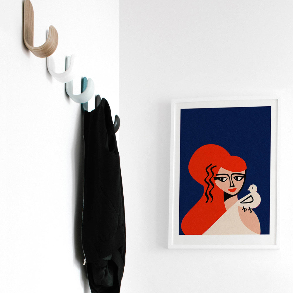 The Aphrodite artwork framed in a minimal hallway setting, its strong graphic composition and deep colour contrast making it a quiet yet captivating focal point.
