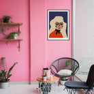 Blonde portrait print hanging on pink wall above indoor plants and black café chairs