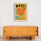 Fun fruit poster styled above a minimalist wooden sideboard.