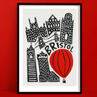 Bold black-and-white cityscape of Bristol featuring a striking red hot air balloon illustration.