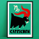 Capricorn zodiac art print featuring a stylised black goat with a red curved tail and white zodiac symbol, framed on a mint green background.