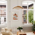 Carousel horse print framed above cream sofa in airy room with large windows and indoor plants