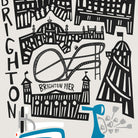 A framed art print featuring a stylized black and white illustration of Brighton landmarks with a bright blue scooter, hanging on a light beige wall above green cabinets.