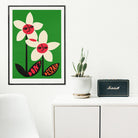 Don’t Despair flower artwork framed in a bright, white room beside a plant and cabinet speaker.