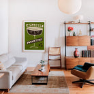 Espresso Martini print hanging in a stylish living room with a white sofa, wood shelving, and soft ambient lighting.