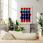 The Flicker print hanging in a bright, plant-filled room, its bold vertical rhythm and rich colours lending an air of movement and modernity to the space.
