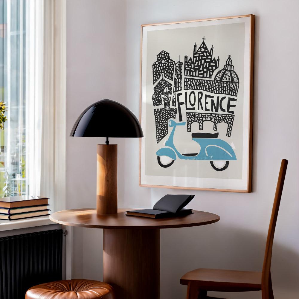 Framed Florence print styled in a cosy home workspace, showing how the iconic Italian landmarks and scooter lend character to a quiet, modern reading nook.