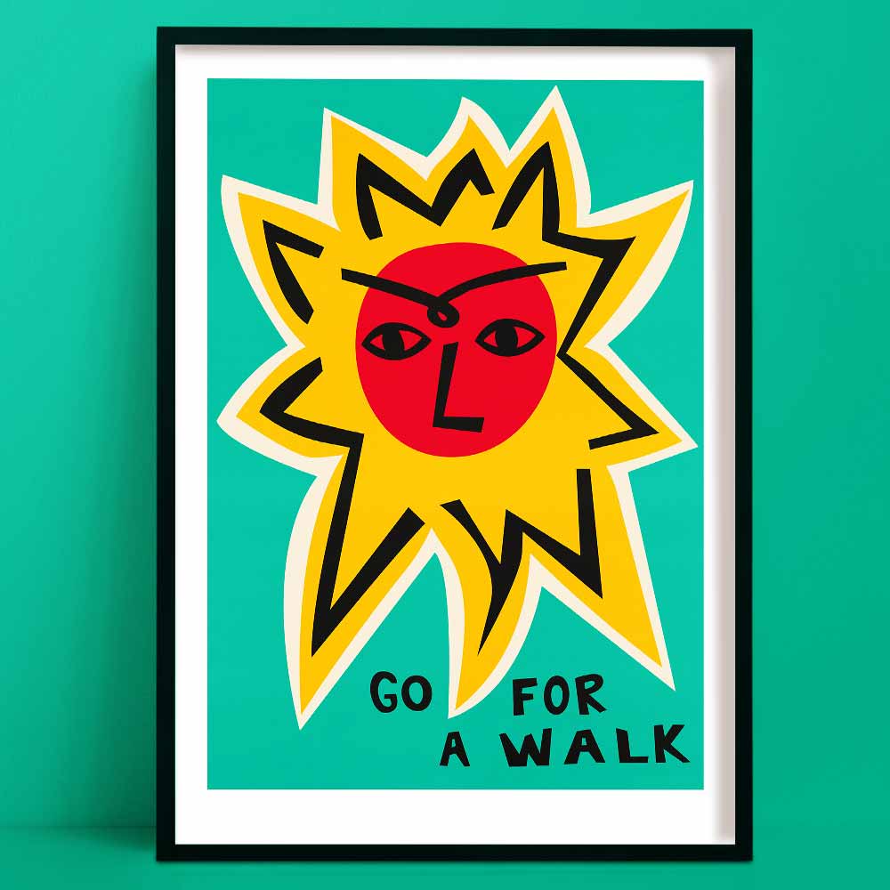 Go For a Walk art print featuring a bold red sun face with yellow rays and hand-lettered text, framed on green wall.