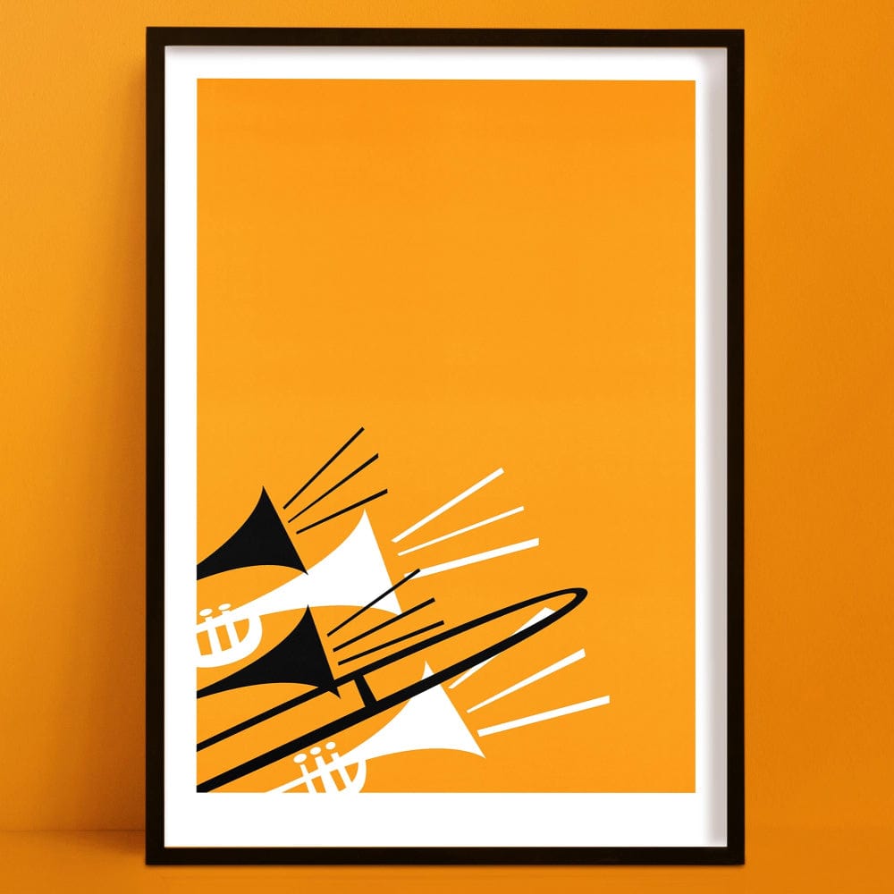 Framed abstract brass instruments print featuring trombones and trumpets in black and white on a vivid orange background