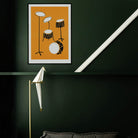 Drum kit art print hanging on a dark green wall with a white diagonal ceiling beam and spotlight below