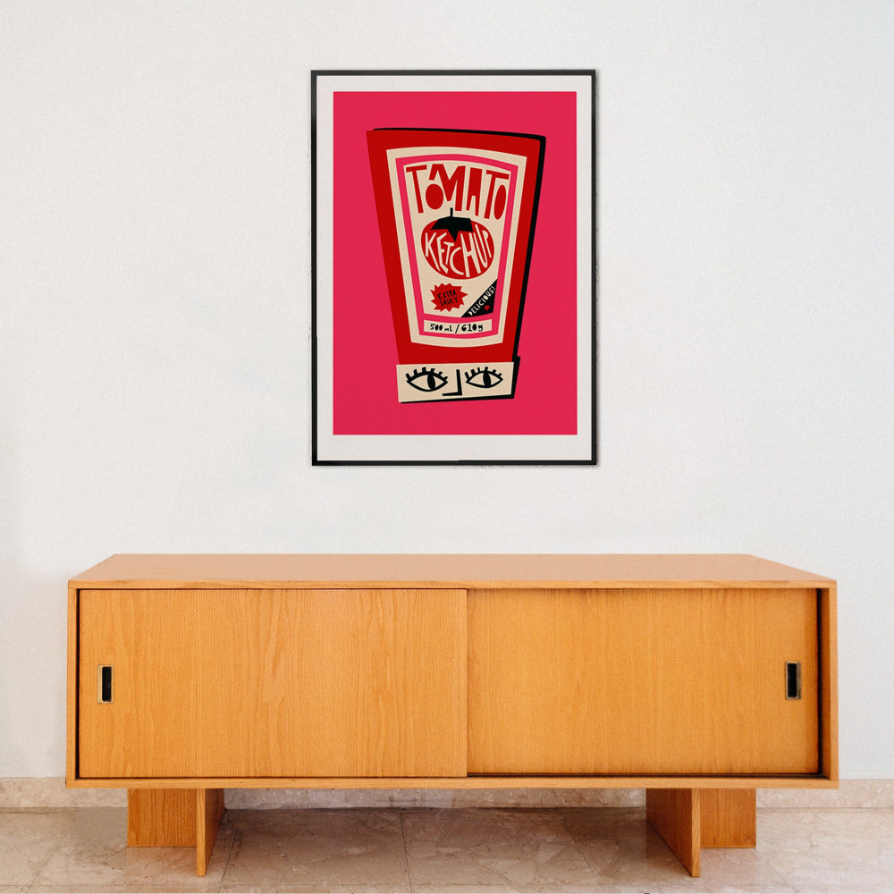 Tomato Ketchup poster framed on a white wall above a minimalist wood sideboard in a modern interior.