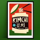 Kimchi art print featuring a cream jar with black label, bold chopsticks, and graphic Korean text, framed on green wall.