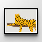Framed Leopard wall art print featuring a stylized yellow leopard with black spots standing on a brown horizontal shape, shown in a black frame against a light gray wall.