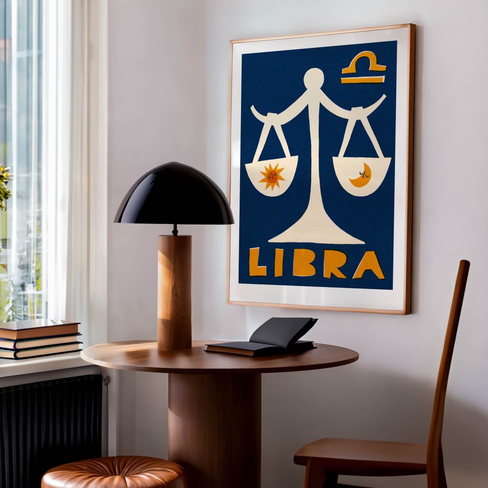 Libra zodiac poster framed above a desk and chair in a cosy reading nook with soft natural light.