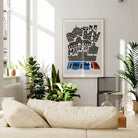 Madrid city print framed above a soft cream sofa and surrounded by greenery in a modern, relaxed setting.