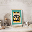 Mayonnaise poster styled on a stone wall kitchen shelf with utensils and glassware.