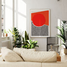 The red circle abstract print displayed in a sunlit living space, its bold geometric form adding warmth and graphic impact to a calm and neutral-toned room.