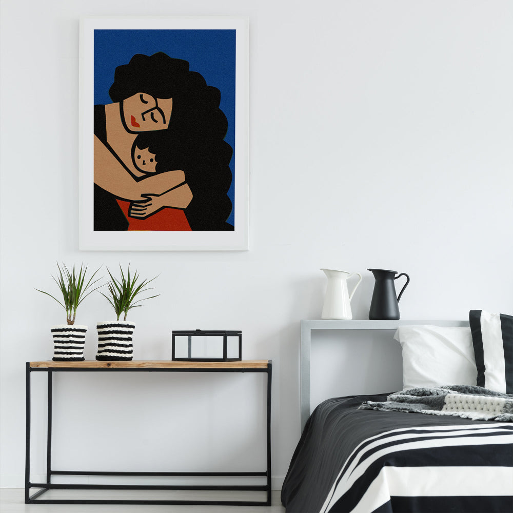 The mother and child print hangs above a monochrome bed, adding an emotional focal point to the space with its modern, soulful depiction of maternal love.
