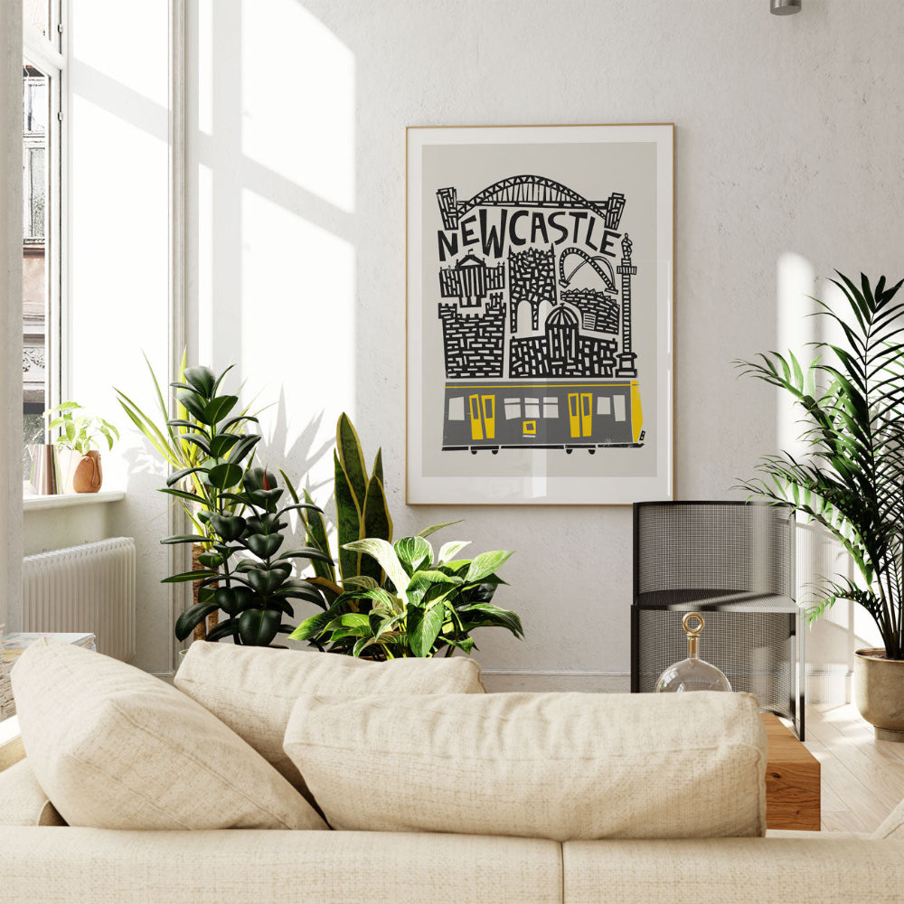 Newcastle artwork styled above a light-toned couch, capturing the balance of urban charm and graphic flair, with the Metro train providing a punch of geometric colour.