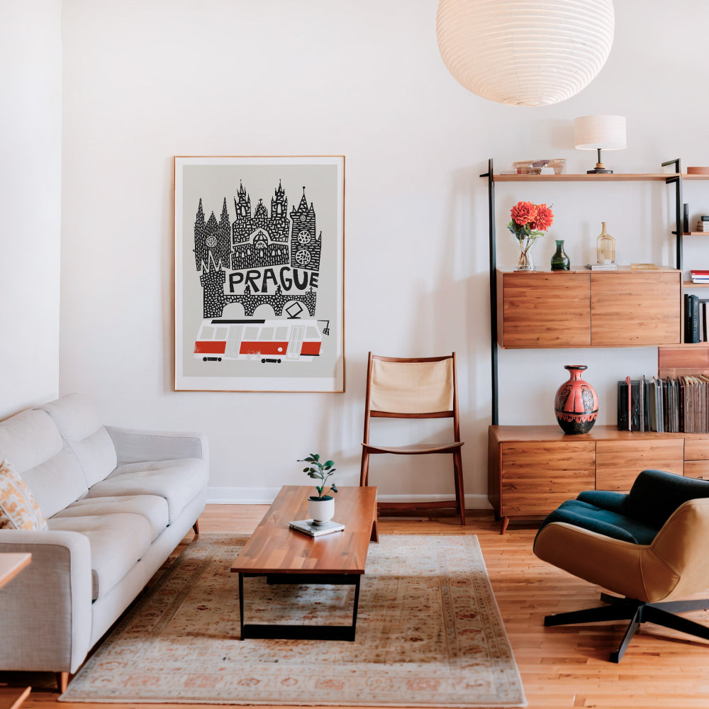 Framed Prague wall art placed above a wooden sideboard in a mid-century styled lounge, blending traditional cityscape with contemporary decor.