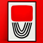 Bold abstract print with red block and black arches, framed and set against a matching red wall.