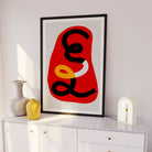Red abstract print framed above white sideboard with ceramic vases and soft lighting
