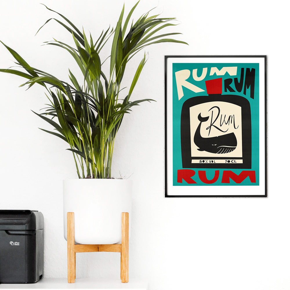 Rum-themed art print with playful shapes and bold colours, styled with leafy plants on a green wall.