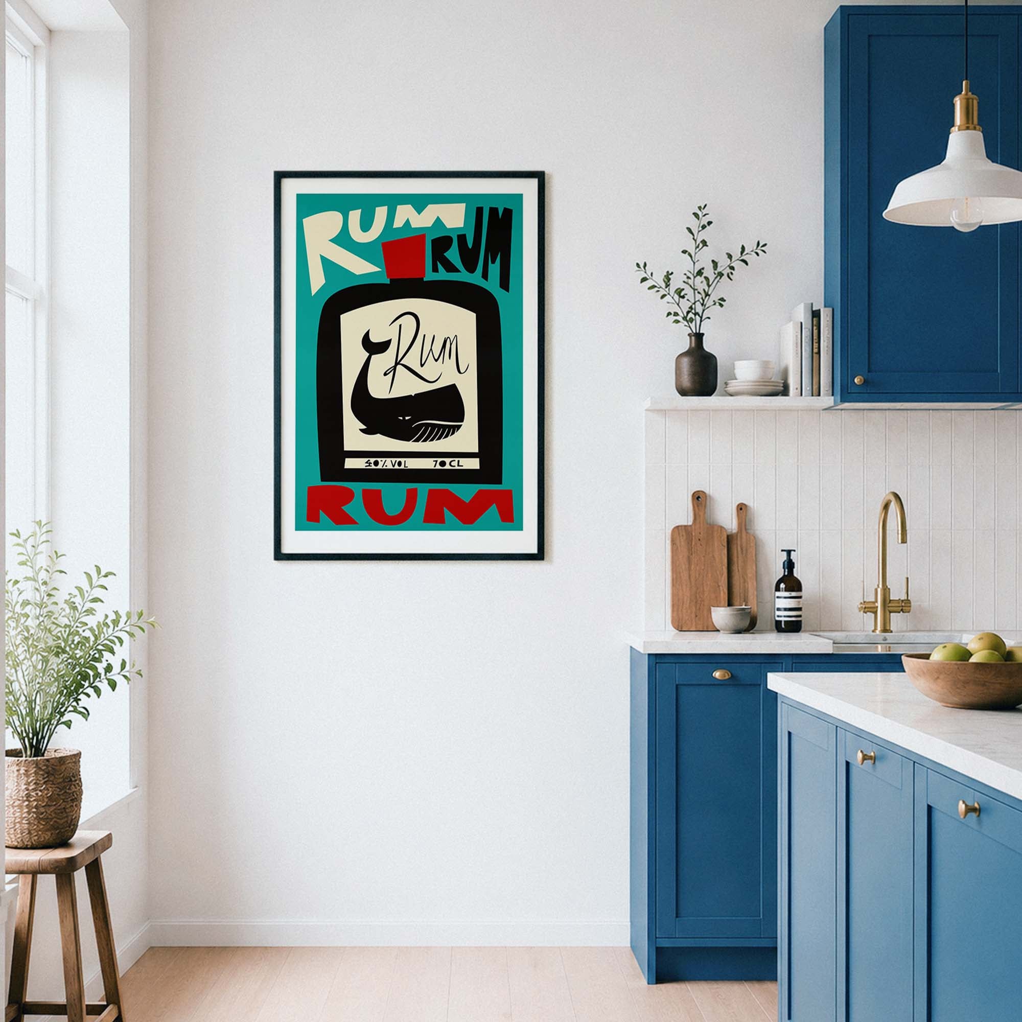 A framed vintage-style Rum poster hangs on a white kitchen wall. The poster features a black bottle illustration with the word 'Rum' and teal, cream, and red lettering.