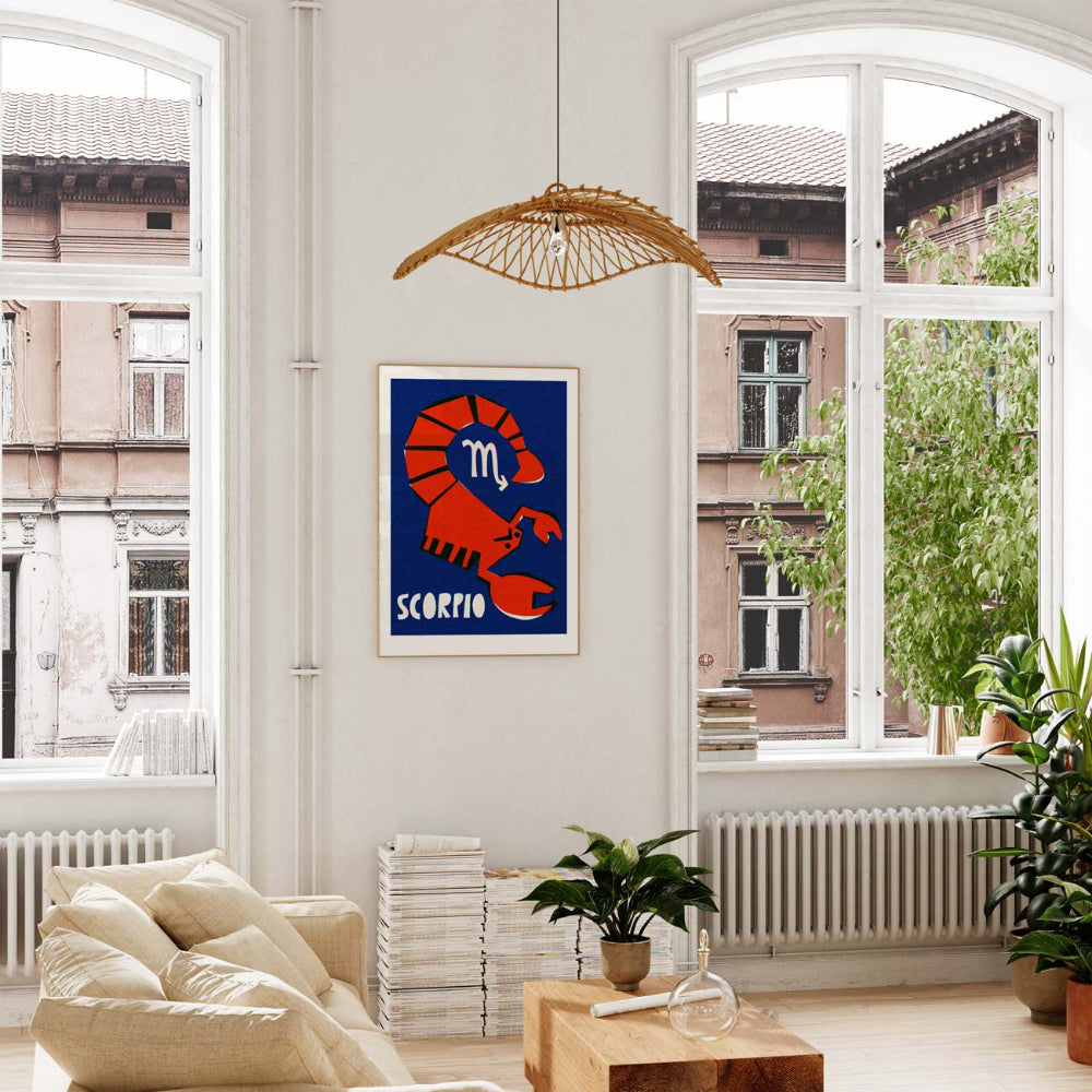 Scorpio print framed in a light-filled room with tall windows, leafy plants, and wooden decor.