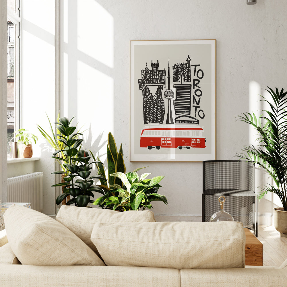 The Toronto print displayed above a beige sofa in a cosy corner, balancing crisp urban lines with the warmth of a handmade, screenprint-inspired texture.

