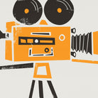 A close-up of the print showing the texture and fine details of the orange and black vintage movie camera illustration, highlighting its charming retro aesthetic.
