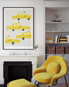 A contemporary room featuring the yellow taxi art print above a fireplace with a matching mustard chair – a playful yet elegant interior moment.
