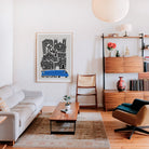 York city print framed above a bench in a retro-modern living space, paired with wood tones and soft lighting.