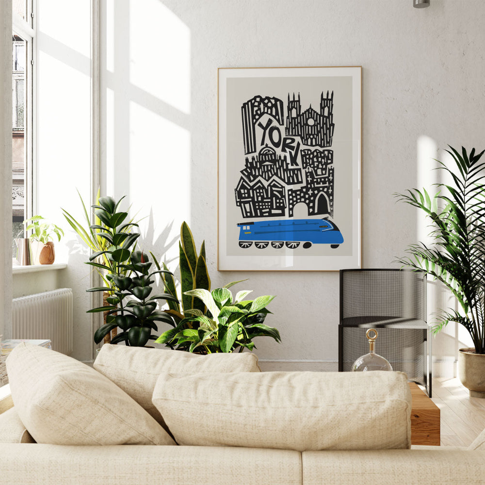 York city poster hanging above a neutral sofa with leafy indoor plants, set in a light-filled, modern lounge.
