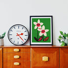 Don’t Despair print framed above a vintage wooden cabinet, styled with plant and clock.