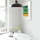 Framed lime illustration hanging above a sleek white sink, adding a pop of colour to the space.